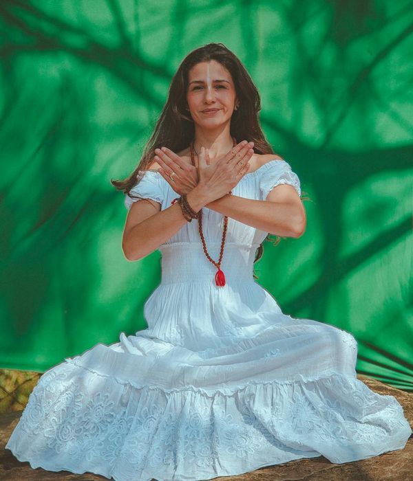 Woman performing a graceful yoga pose in a tranquil setting.